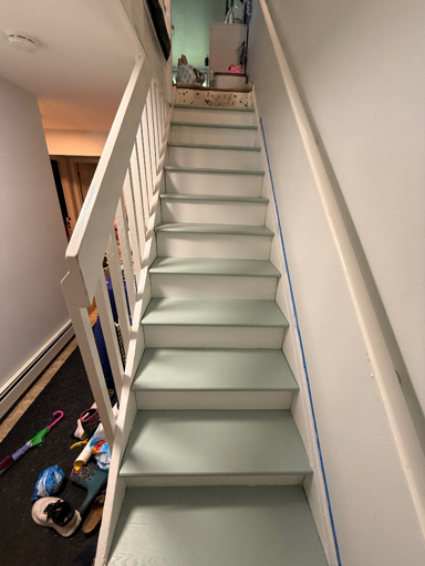A freshly painted stairway, the rails and risers are white while the treads (steps) are a lite mintsish green. 